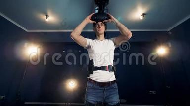 一个人戴上虚拟现实护目镜开始移动他的手。 虚拟现实耳机玩游戏360..